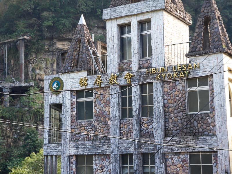 A large, stone and cement church with Mandarin characters on the side