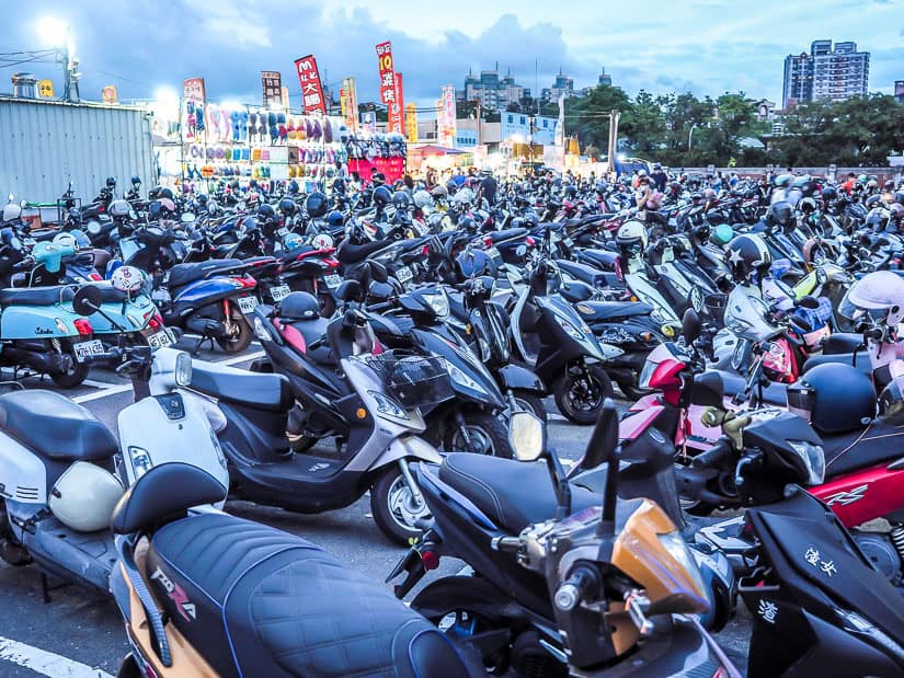 A parking lot full of hundreds of scooters just outside a night market in Taiwan