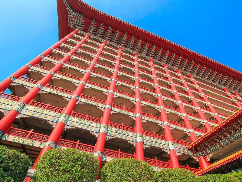 Looking up at a large, classical Chinese style red hotel building, the Grand Hotel, in Taipei