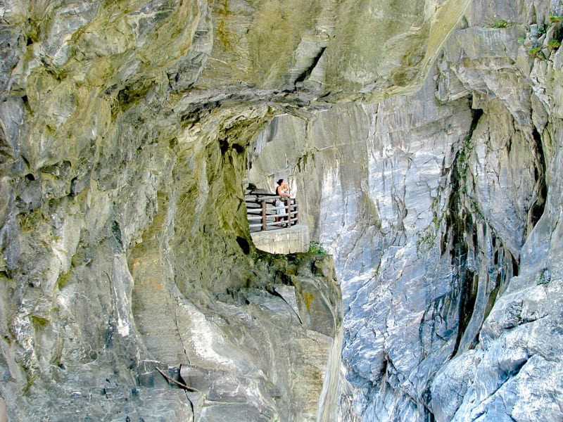 Two women standing on a platform surrounded by marble cliffs