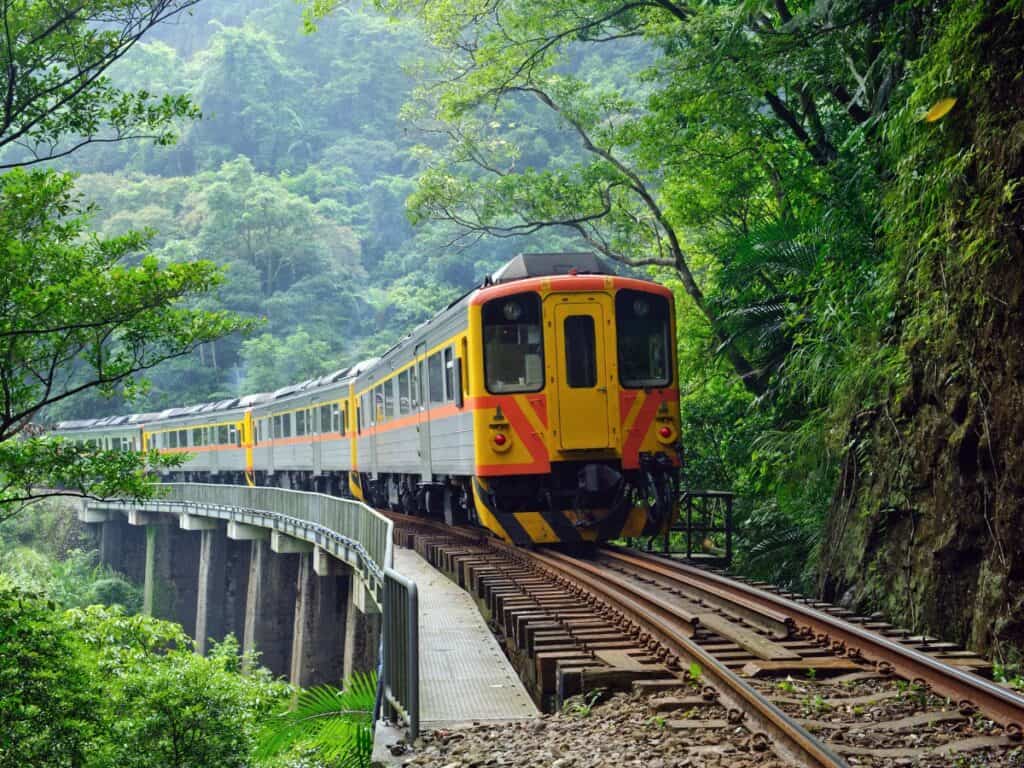 A train car of the Pingxi Line crosses a bridge in the forest