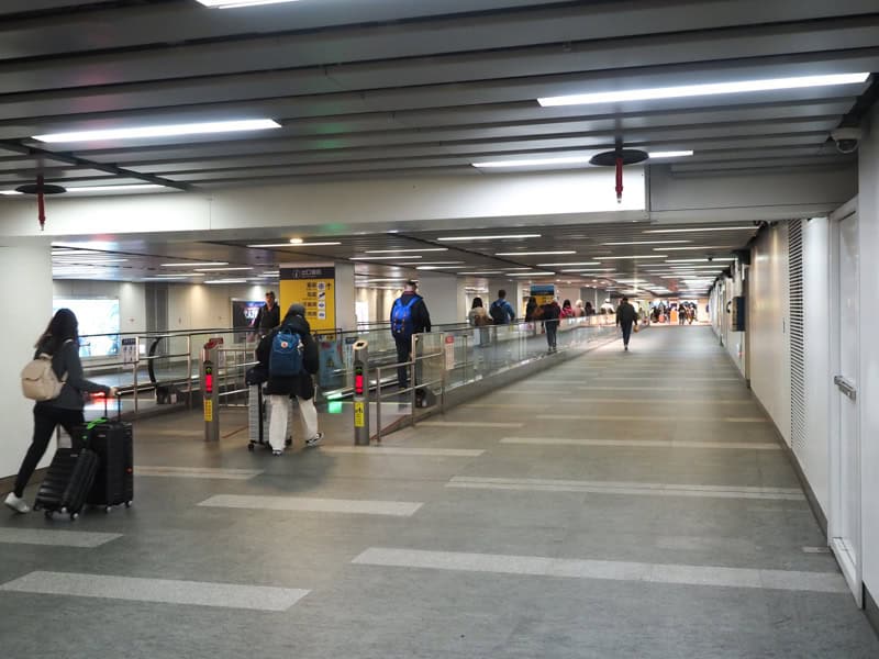 An underground tunnel with some passengers walkthrough through