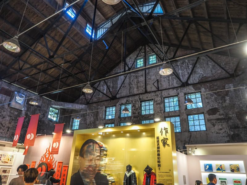 Looking up in an old warehouse room at the old ceiling, with the upper parts of some exhibit displays below