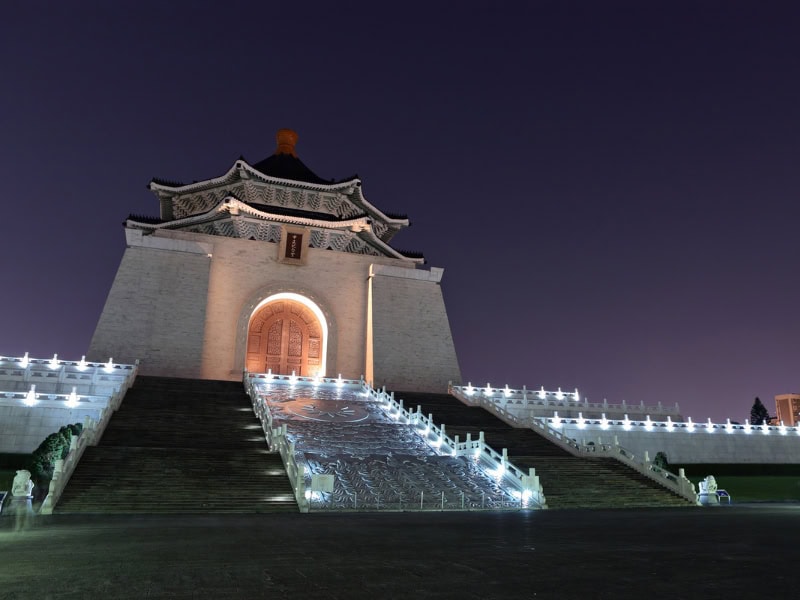 The front of Chiang Kai-shek Memorial Hall lit up at night, with lights going up the stairs leading up to it