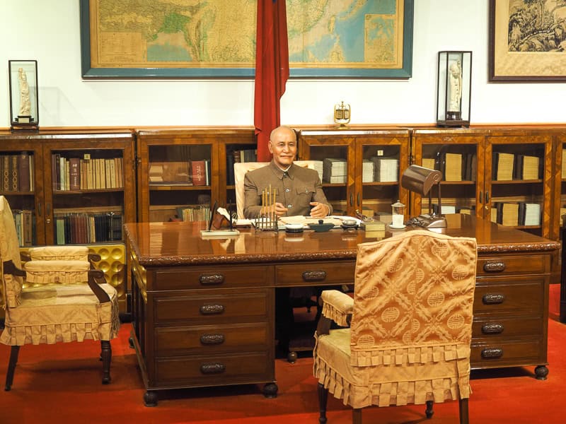 A model figure of Chiang Kai Shek sitting at a desk in his office, in the CKS Memorial Hall Museum