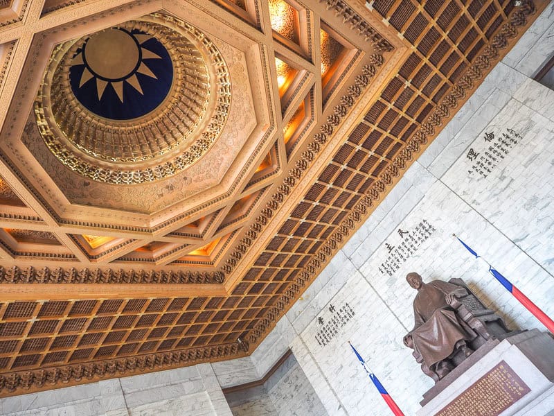 An angled photo showing bronze statue of CKS on the bottom right and a highly decorative domed ceiling on the top left with ROC flag sun in the middle of the dome