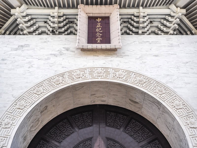 The top of a large entrance arch to CKS Memorial hall, with a plaque above that says 中正紀念堂