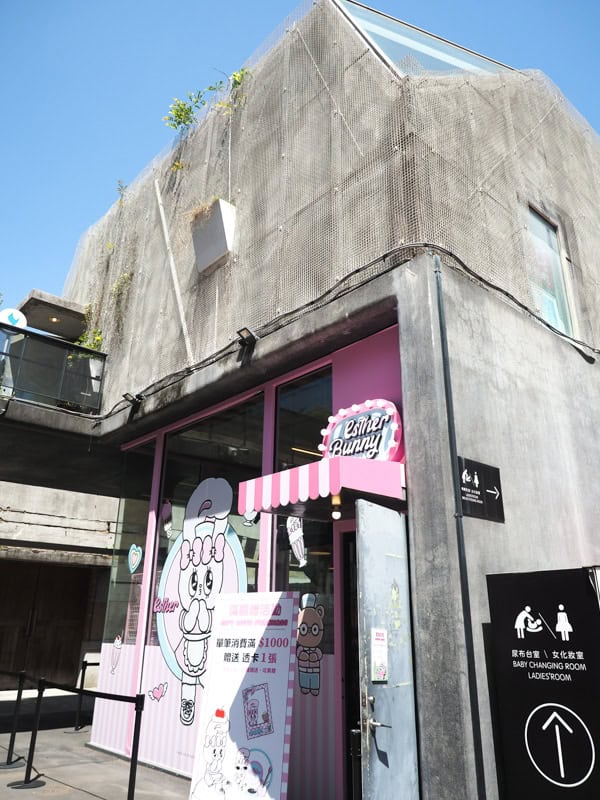 A cute pink Esther Bunny storefront at the bottom of a two-storey cement building