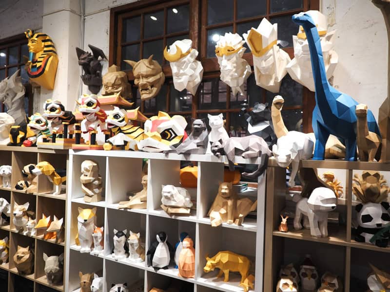 A shop display with many colorful 3D animals made out of paper