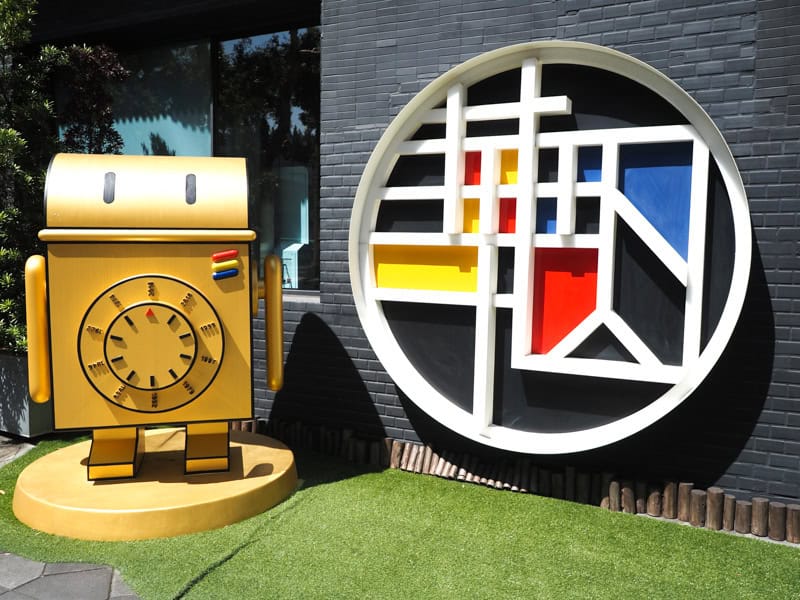 A round sign that says 華山町 in stylized Mandarin characters and a golden robot statue