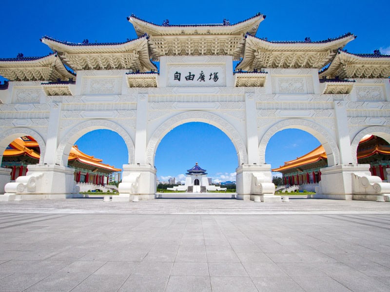 Three arched of the white Liberty arch, with Liberty Square and CKS Memorial Hall beyond