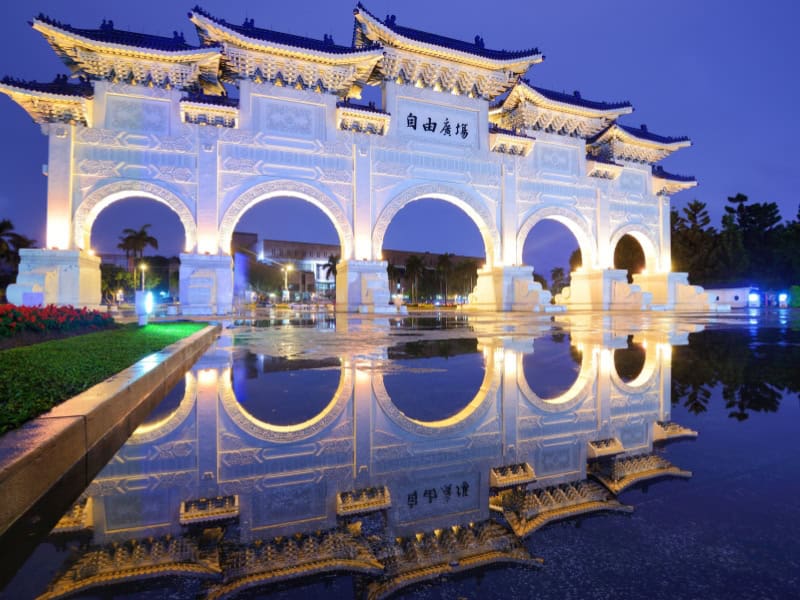 Liberty Arch at CKS Memorial Hall reflecting in a puddle in the evening