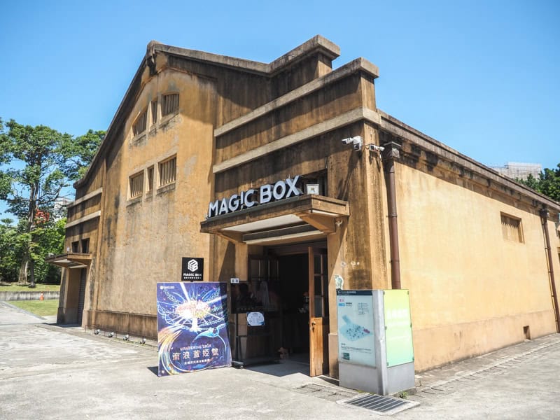 An old beige colored building with sign above door that says Magic Box