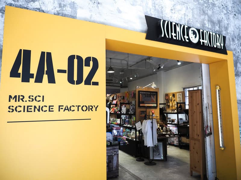 The entrance to a store called Science Factory with large yellow sign on the side