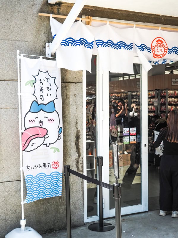 A sign outside a pop-up store in Huashan with some sushi-shaped cat characters on the sign