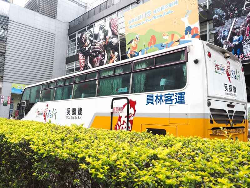 A yellow and white Taiwan tourism shuttle bus parked at Sun Moon Lake bus stop