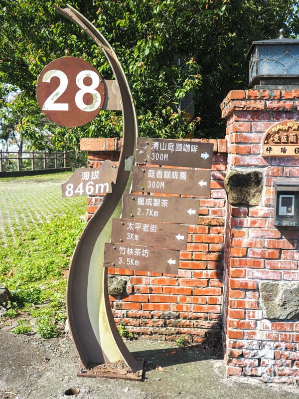 A vertical sign that says 28 and has several more signs sticking out showing directions to various places in Mandarin