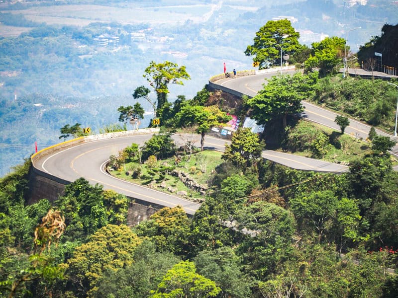 Some switchbacks on a highway shot from far away, with a plain behind and far below them