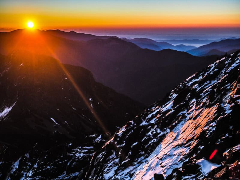 The rising sun illuminates the peak of Mount Jade