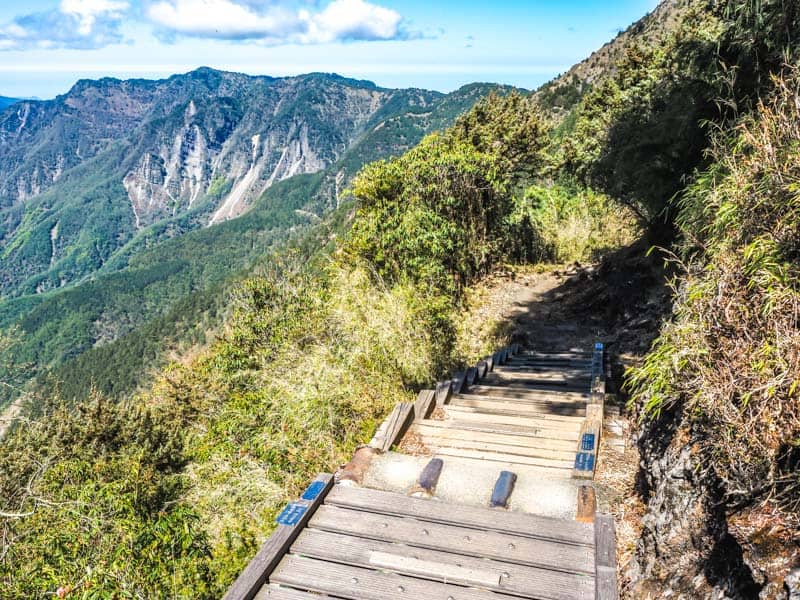 Looking down a wooden staircase and mountain view to the left
