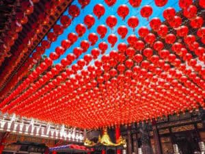 Looking up at a canopy of red lanterns in the internal courtyard of Sanfong Temple in Kaohsiung