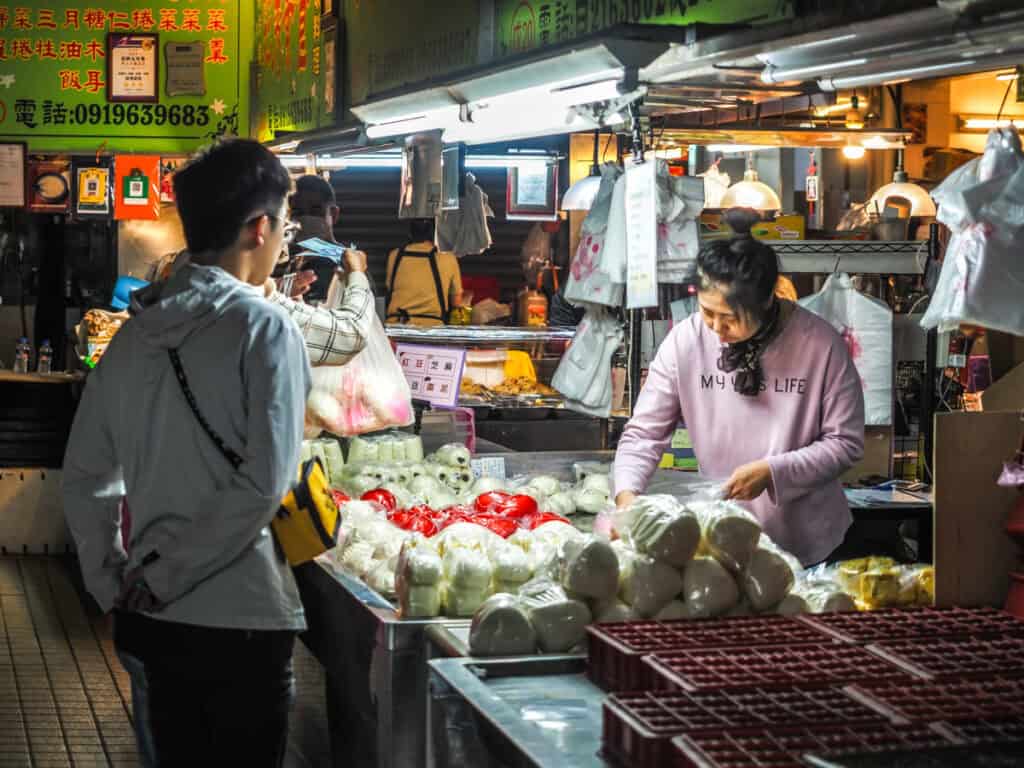 A couple locals buying steamed buns from a vendor in Sanmin Traditional Market