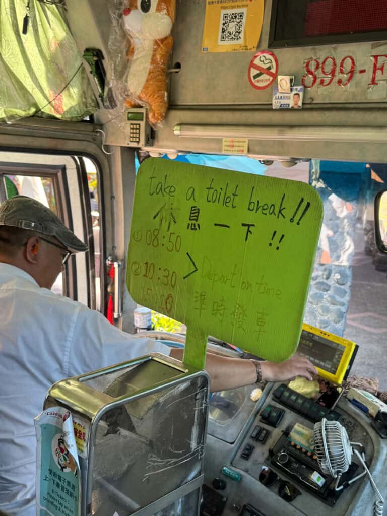 Bus driver on the Sun Moon Lake to Alishan bus with a sign showing the times of the breaks on the way