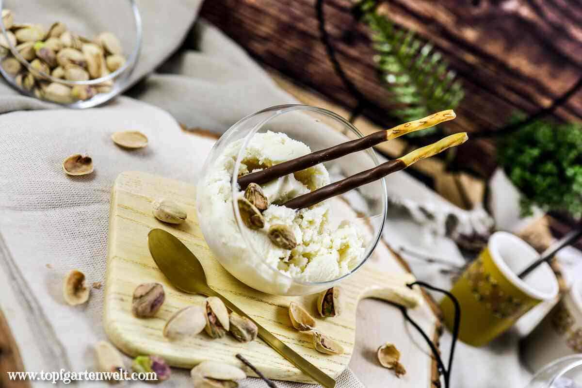 Pistazieneis einem halbrunden kleinen Glas. Daneben liegt ein goldener Löffel. Foodblog Topfgartenwelt