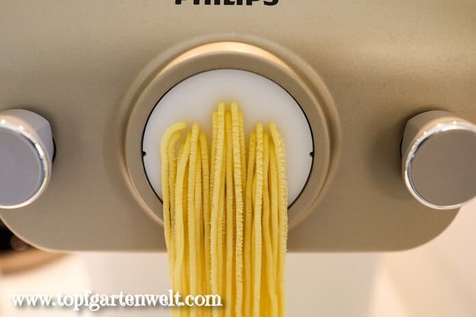 Eine Pastamaschine für zu Hause, die gerade Spaghetti ausgibt.