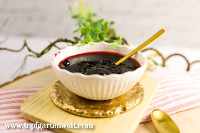 Eine Schale mit Holunderbeerengelee steht bereit zum Essen. Es schmeckt super zum Frühstück.