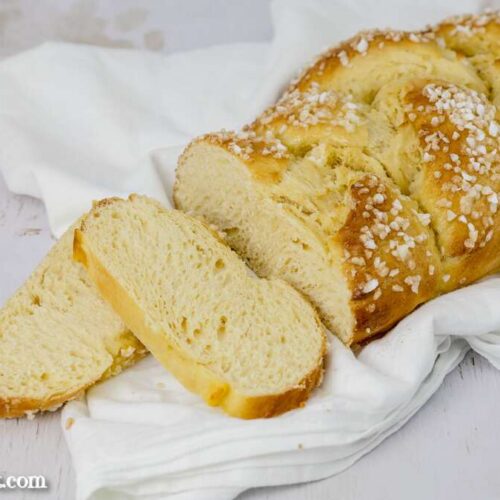 Auf einem weißen Tuch liegt ein angeschnittener Allerheiligenstriezel.