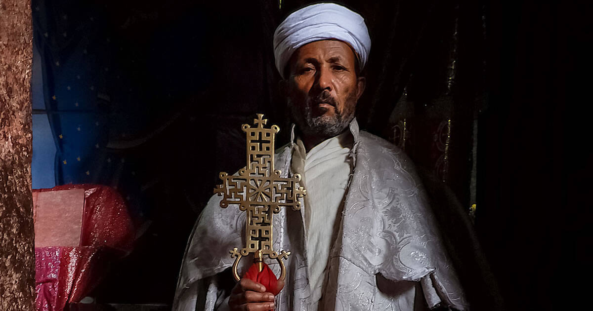 An Ethiopian Christian Priest Holding a Bronze Cross Featured