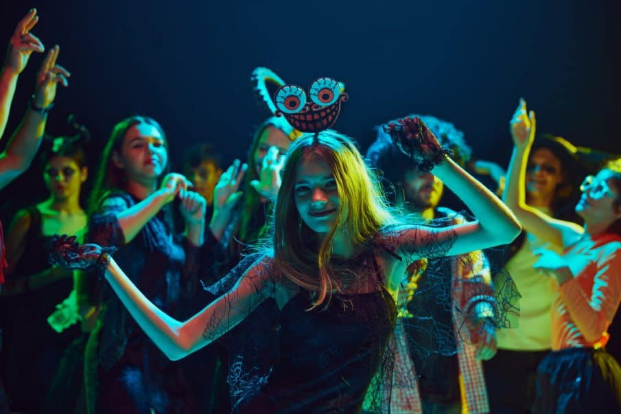 A girl dancing joyfully at a themed 18th birthday costume party in warsaw, captured by a professional event photographer.