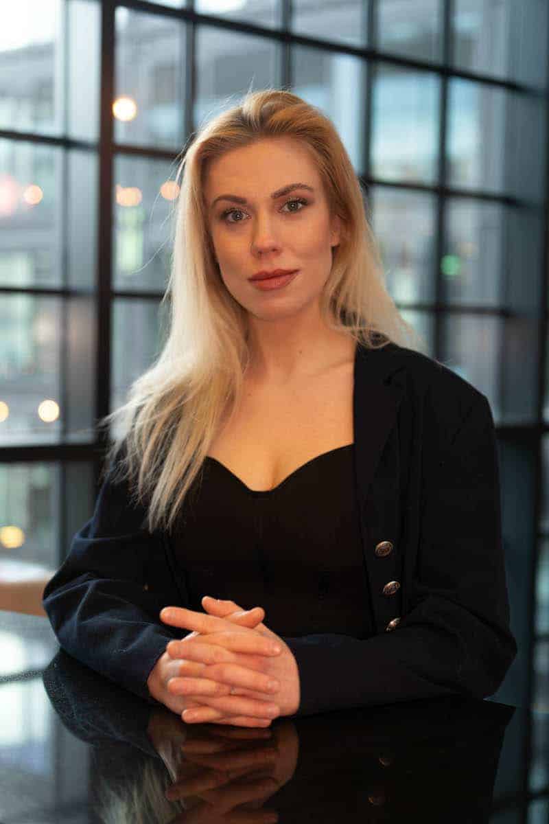 Kobieca sesja biznesowa w studio fotograficznym — elegancki portret z profesjonalnym retuszem, idealny do wizerunku zawodowego.