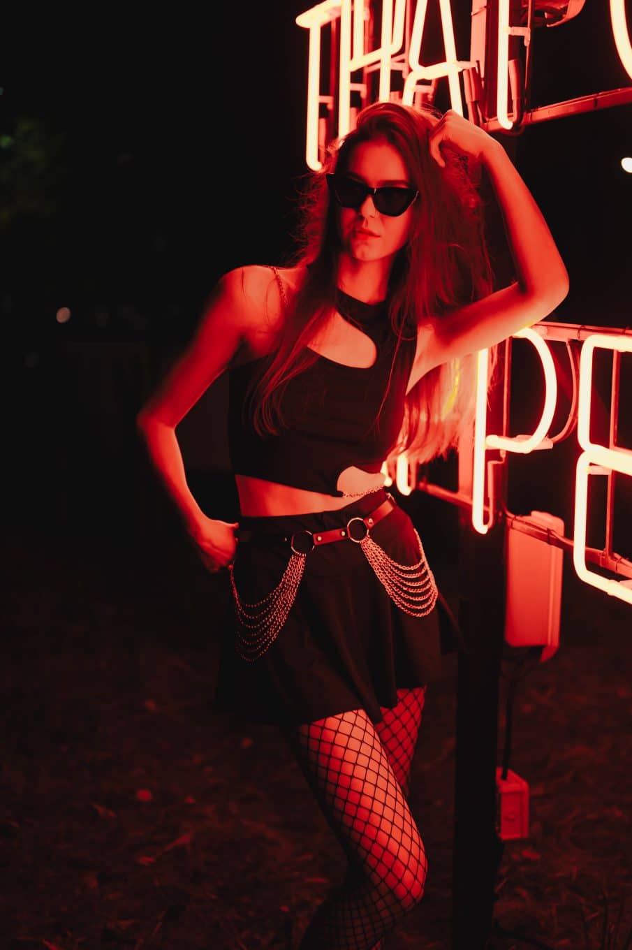 Kobieca fotografia plenerowa w warszawie — nocna sesja przy neonowych światłach, pełna miejskiego klimatu i energii.