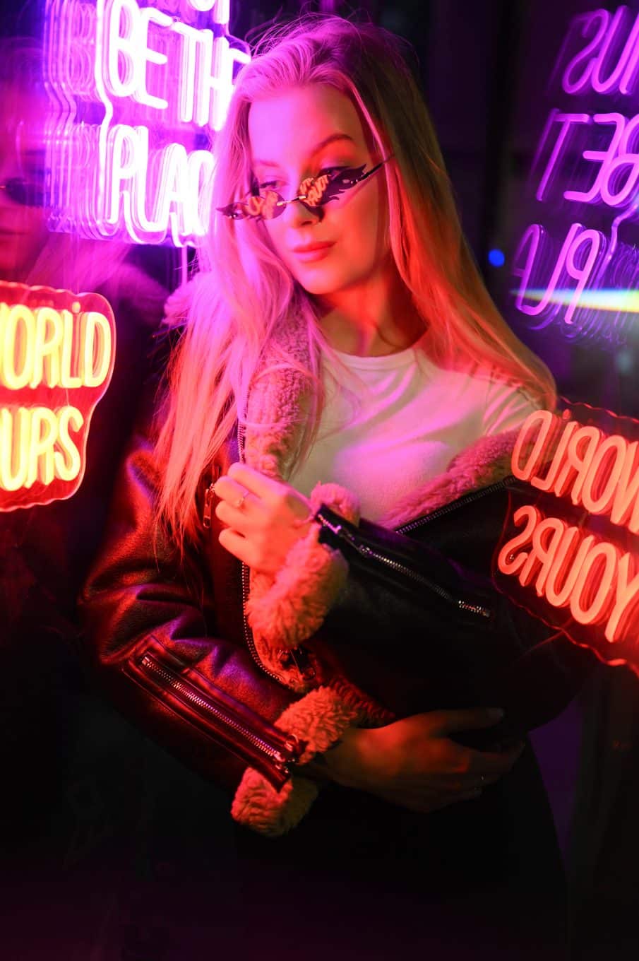 Modelka w skórzanej kurtce przy neonowym napisie. Sesja fotograficzna warszawa w nocnej scenerii.