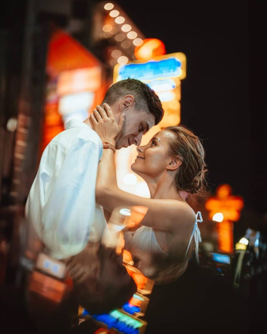 Romantyczna sesja neonowa pary w miejskiej atmosferze warszawy. Intymne ujęcie zakochanych w wieczornym świetle, z kolorowymi neonami w tle. Profesjonalne zdjęcia lifestylowe pary z miasta wykonane przez fotografa z warszawy.