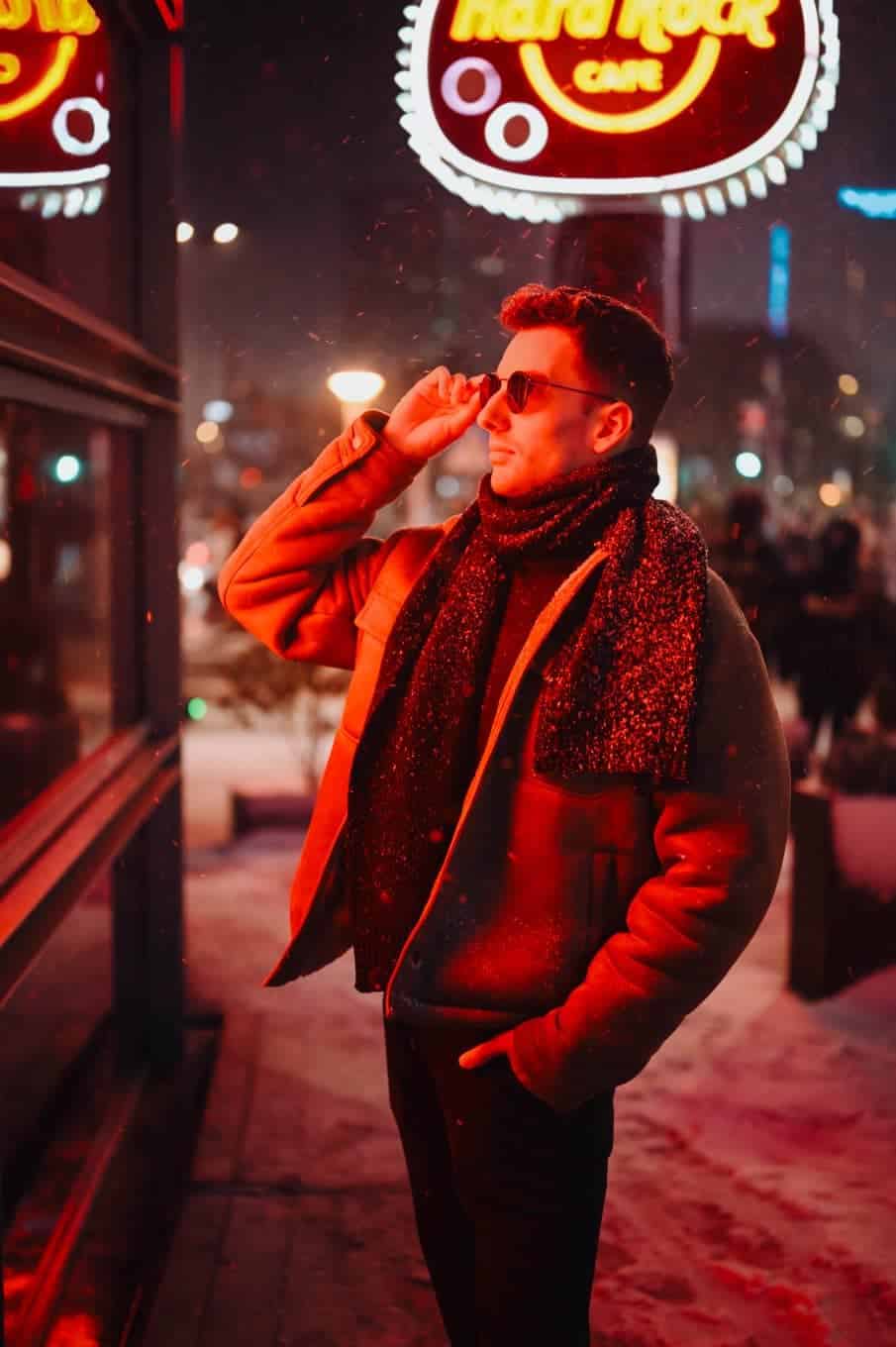 Portret męski w okularach na tle neonu hard rock cafe nocą. Fotograf portretowy i profesjonalne zdjęcia warszawa