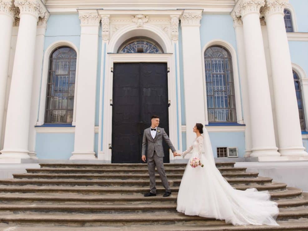 Fotografia slubna przed kościołem w warszawie. Elegancki portret na monumentalnych schodach uchwycony podczas reprtaż ślubny