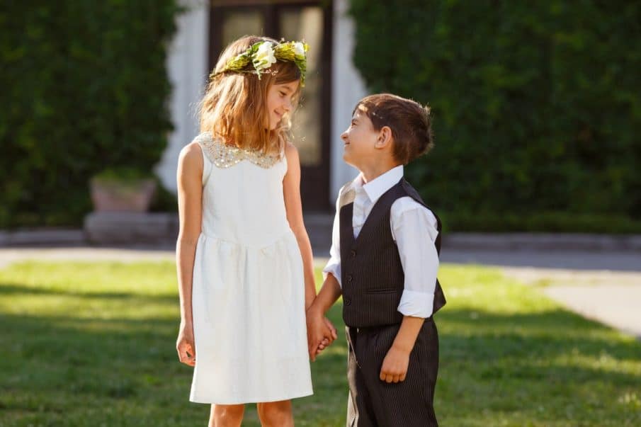 Dzieci na ślubie trzymające się za ręce. Uroczy dodatek do każdej fotografii weselnej i fotografii ślubnej