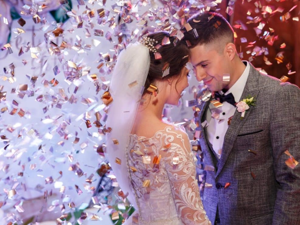 Magiczna fotografia weselna: romantyczny taniec pary młodej w deszczu konfetti. Reportaż ślubny pełen emocji