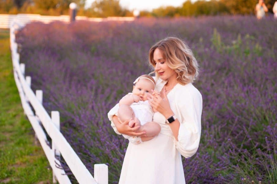 Sesja rodzinna lawenda warszawa: piękny plener na polu lawendy o zachodzie słońca. Kobieta trzymająca niemowlę. Idealne zdjęcia rodzinne w stylu boho