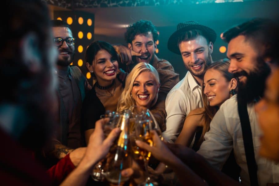 Profesjonalny fotograf na imprezy okolicznościowe, kadr radosnych gości wznoszących toast.