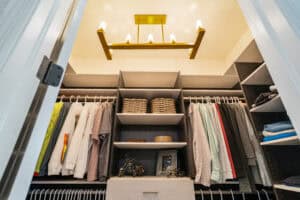 walk in closet with chandelier and clothes hanging