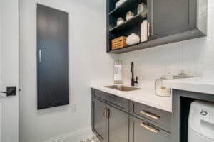 custom laundry room with counter, cabinets, sink