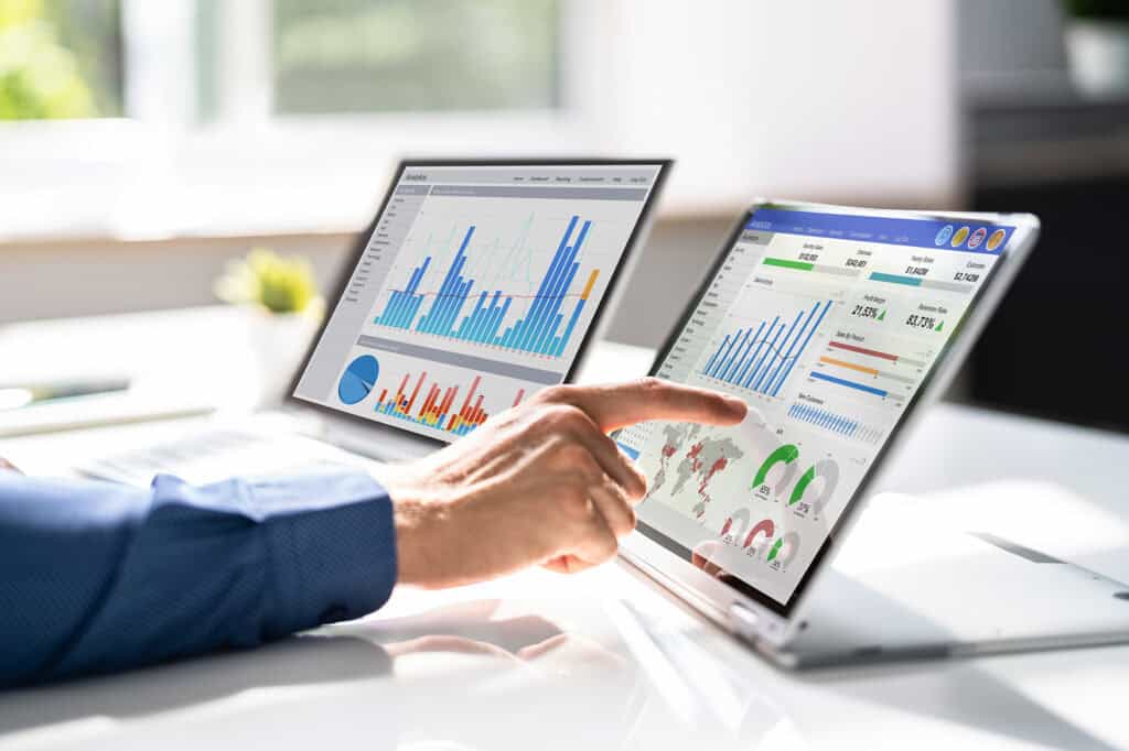 Person analyzing data on dual screens