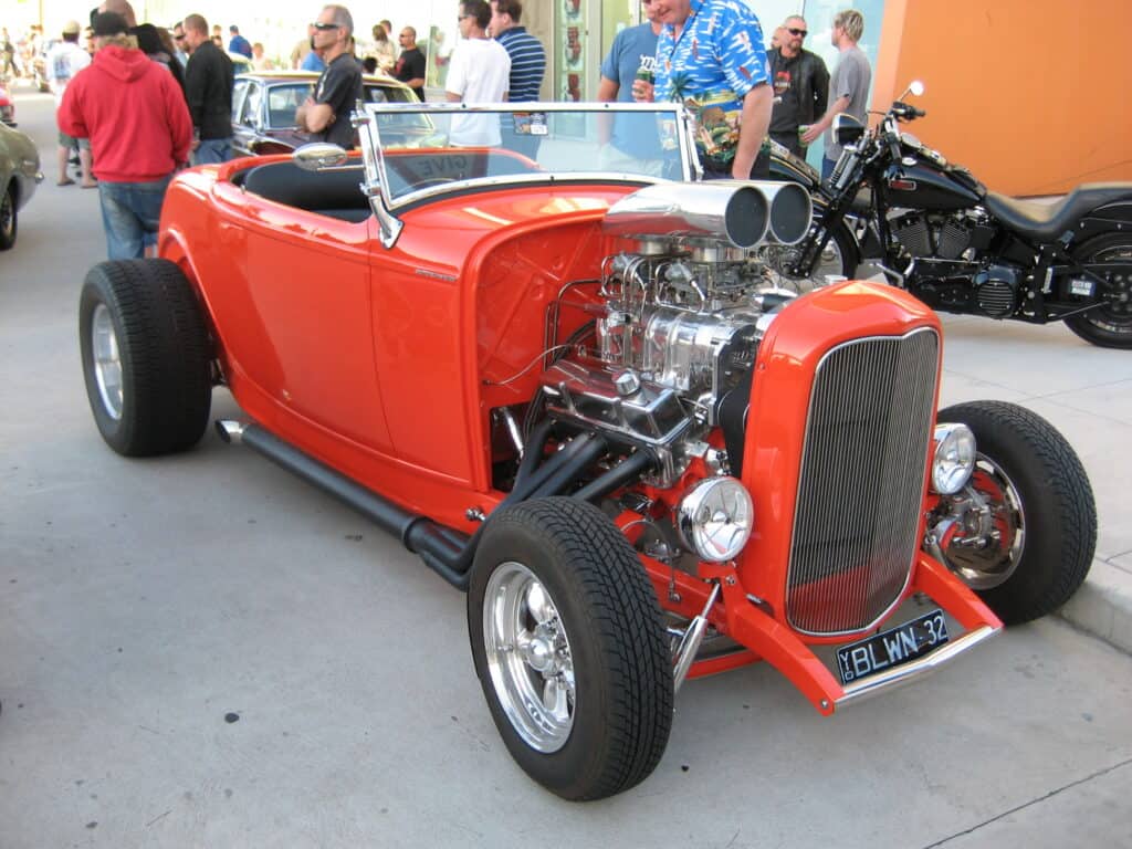 Bright orange 1932 Ford roadster hot rod with exposed engine and fenderless front end