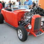 Bright orange 1932 Ford roadster hot rod with exposed engine and fenderless front end