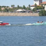 Two Amphicars driving across Lake Mirror during the Lake Mirror Classic
