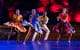 Image of 4 Viver Brasil dancers on stage with dramatic lighting